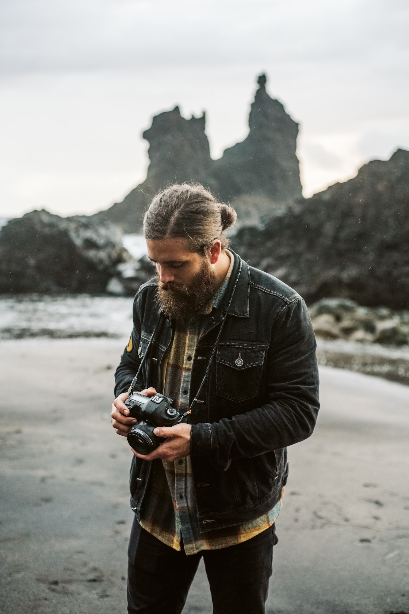 Bearded photographer standing near sea